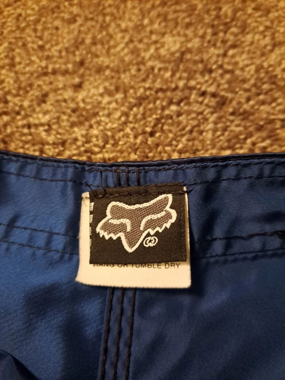 Vintage Fox Racing board shorts featuring a blue satin finish &white piping.